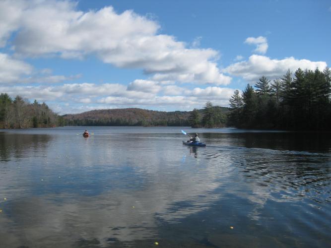 Two Kayakers on lake with fall hills in background