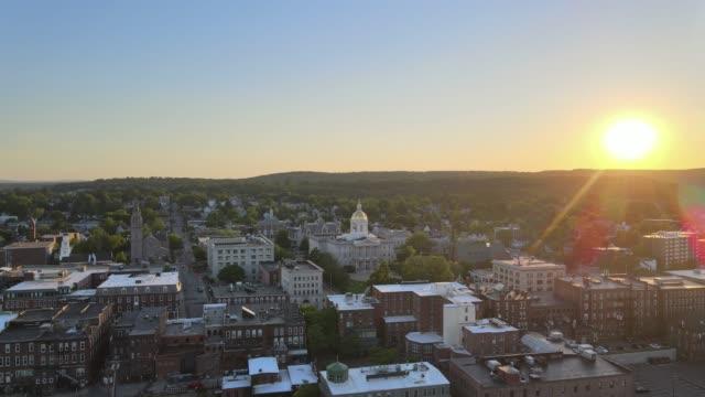Sunrise over downtown Concord rooftops and State House Capitol dome