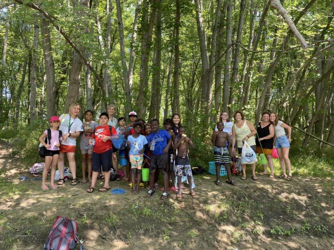 Students pose for a group photo in the shade of silver maple forest