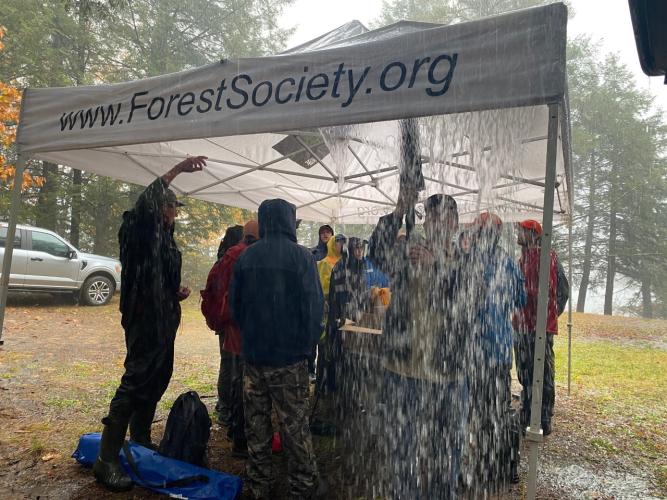 Photo showing rain pouring off of the Forest Society pop up tent