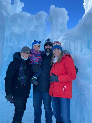 Maria Finnegan and her family pose in front of the blue ice of the Ice Castles.